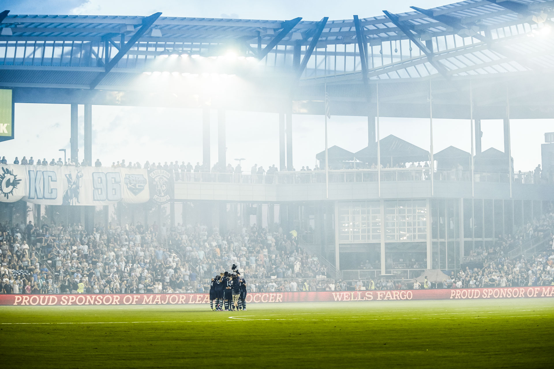 players huddle in front of beautiful Children's Mercy Park